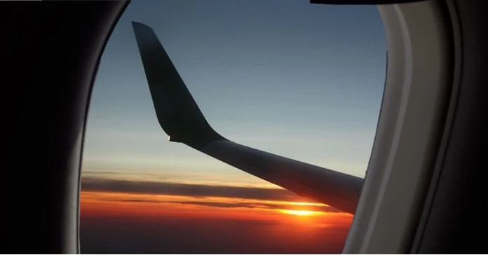 Aile d’avion vue à travers un hublot.